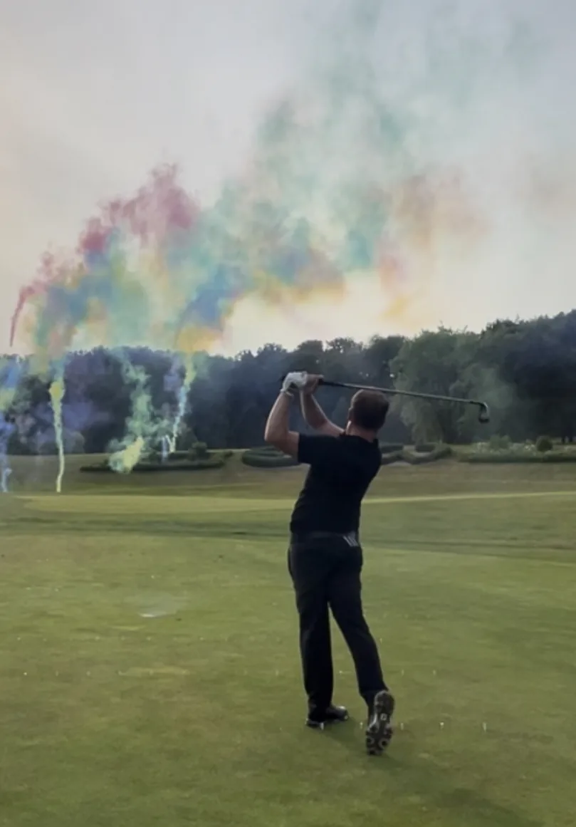 Golfshow mit buntem Rauch vor der Golfkulisse